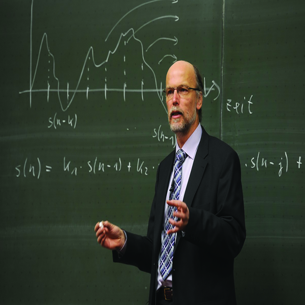 professor standing in front of chalkboard